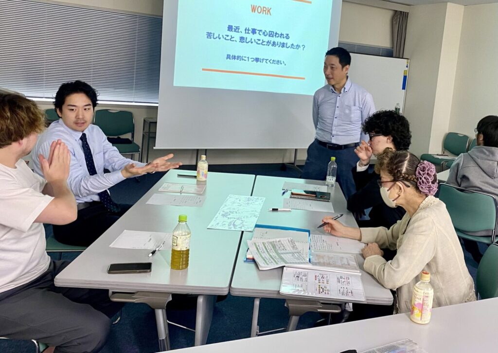 リーダー講座の様子。スクリーンに映した問いについて、講師と受講生が語り合っている